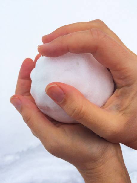 istock Woman hands holding snowball 869455832
