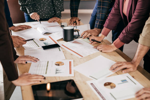 istock Hands and papers with graphs and charts over the desk as business concept 869465604