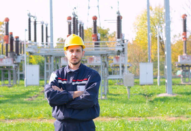 istock Smiling male engineer with arms crossed, at power substation 869466484