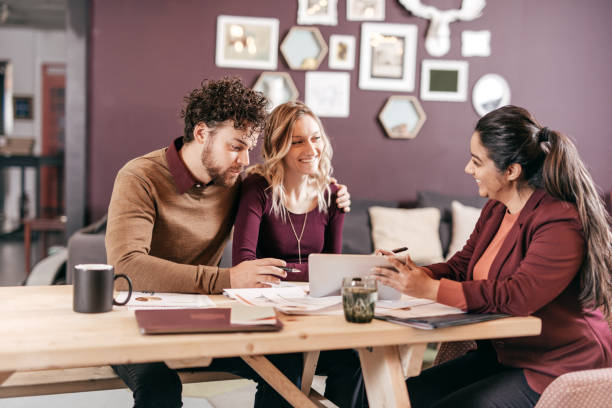 Accountant explaining taxes for couple Multiracial group indoor borrowing stock pictures, royalty-free photos & images