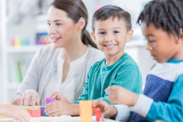 istock Kindergarten age boy smiles for camera at school 869475978