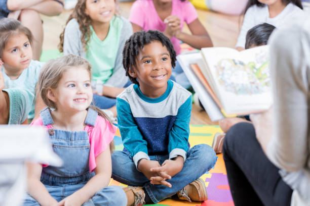 istock Elementary students sit on floor and listen to story 869475988