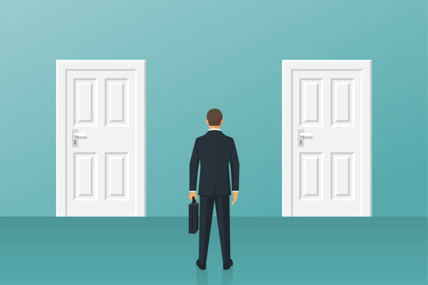 istock Businessman standing in front of two closed doors. 869478086