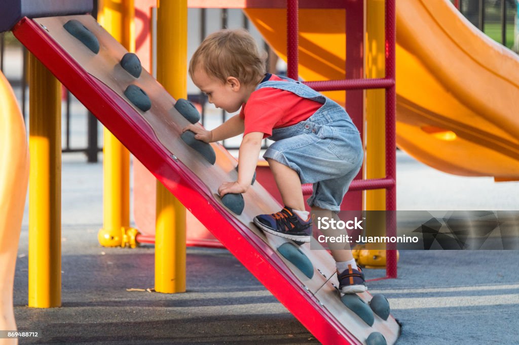 Hombre niño jugando en el patio de recreo - Foto de stock de Niño pequeño libre de derechos
