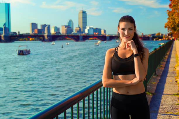 runner femminile di fronte allo skyline di boston, usa - boston charles river skyline massachusetts foto e immagini stock