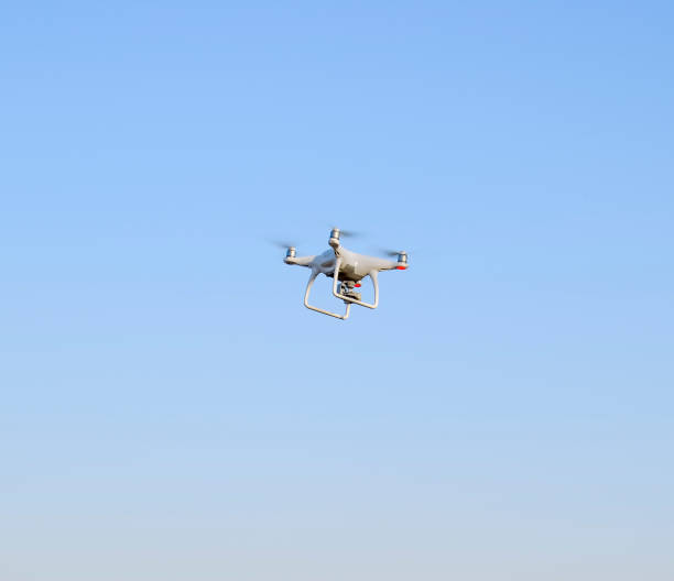 istock White drone against the blue evening sky. Multicopter flight. 869502800