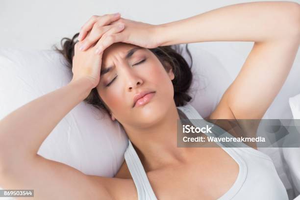 Sleepy Woman Suffering From Headache In Bed Stock Photo - Download Image Now - 20-24 Years, 20-29 Years, Adult