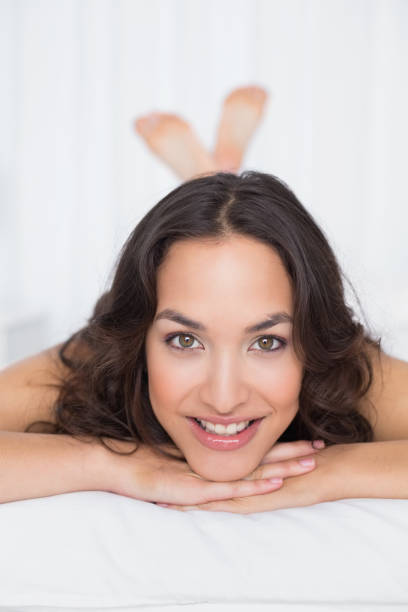 istock Smiling pretty brunette lying in bed 869503722