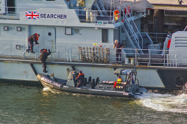 Newcastle, United Kingdom - October 5th, 2014 - UK border force officers boarding a RIB patrol boat alongside the border force cutter HMC Searcher stock photo
