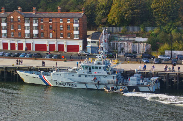 Newcastle, United Kingdom - October 5th, 2014 - UK border force cutter HMC Searcher at her moorings with RIB patrol boat coming alongside stock photo