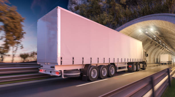 dwie ciężarówki z naczepą przejeżdżające przez tunel o zmierzchu - crash barrier obrazy zdjęcia i obrazy z banku zdjęć