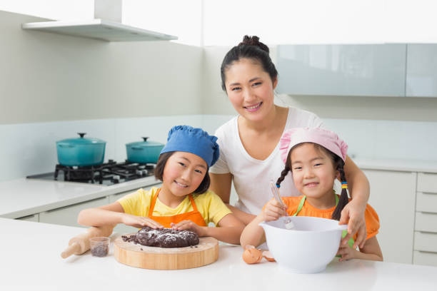 istock Girls with their mother preparing cookies in kitchen 869520352