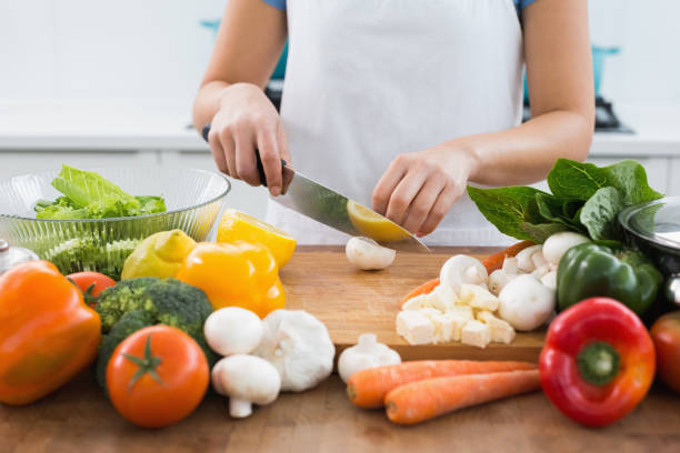 istock Mid section of a woman chopping vegetables in kitchen 869520384