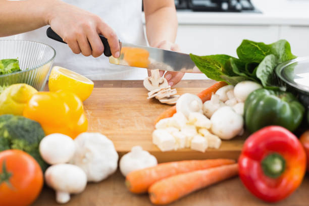 istock Mid section of a woman chopping vegetables in kitchen 869520392