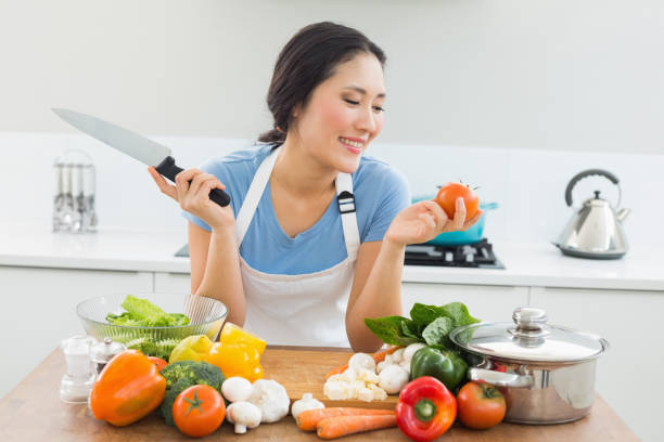 istock Smiling woman chopping vegetables in kitchen 869520438