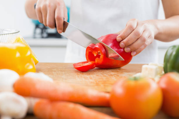 istock Mid section of a woman chopping vegetables in kitchen 869521034