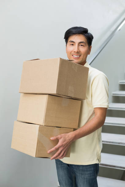 istock Portrait of a smiling young man carrying boxes 869524134