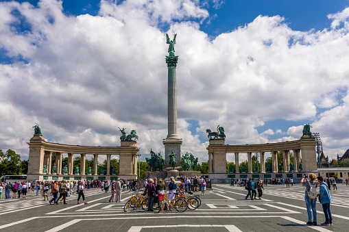 Tourists on a bicycle tour on the Heroes' Square in Budapest, Hungary.