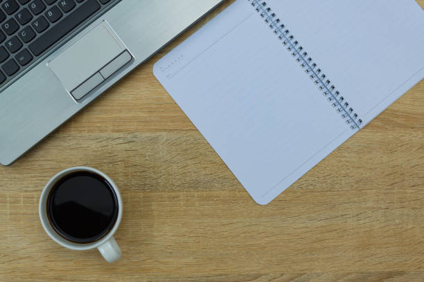 istock Laptop computer or notebook, note and cup of coffee on working table with copy space top view. 869530818