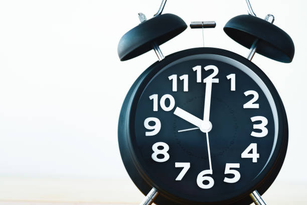 istock Black color vintage alarm clock on table with copy space, wake up time concept 869530888