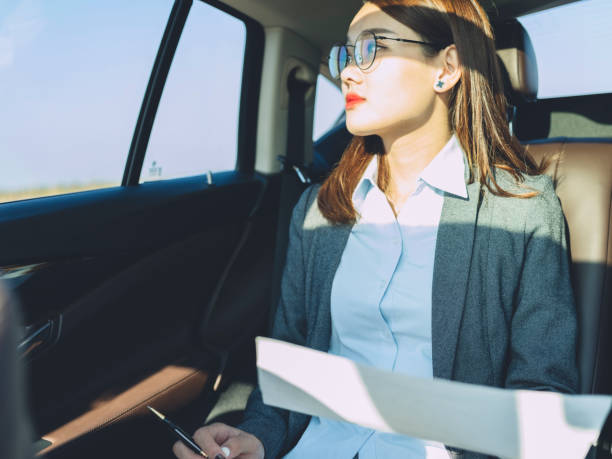 istock business woman working in car with paperwork 869533634