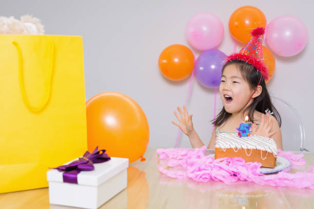 istock Cheerful surprised little girl at her birthday party 869534708