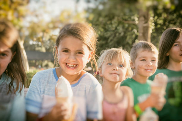 delicioso tratamiento después de un largo día con los amigos y los niños - ice cream licking little boys ice cream cone fotografías e imágenes de stock