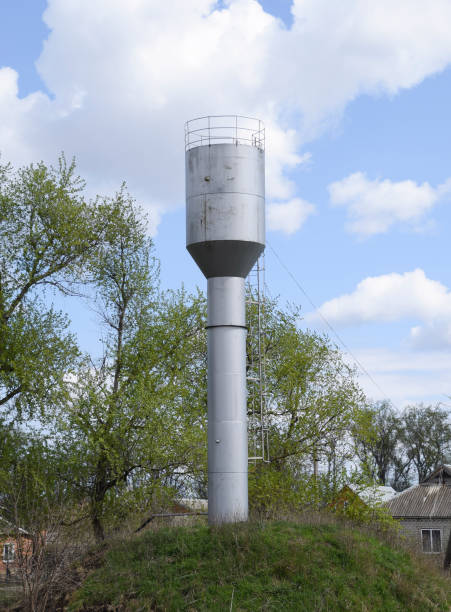 istock Silver Water Tower among green grass and trees 869537942