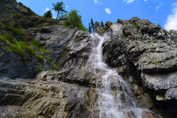 istock Shirlak waterfall in rocks on blue sky with white clouds background. Tektu river, Altai Mountains, Altay Republic, Siberia, Russia 869541152