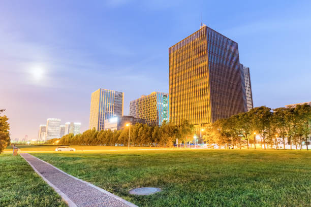 istock park footpath and lawn with modern buildings at night 869541874