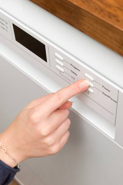 istock Woman's Finger Pressing a Button on a Home Dishwasher Appliance 869547744