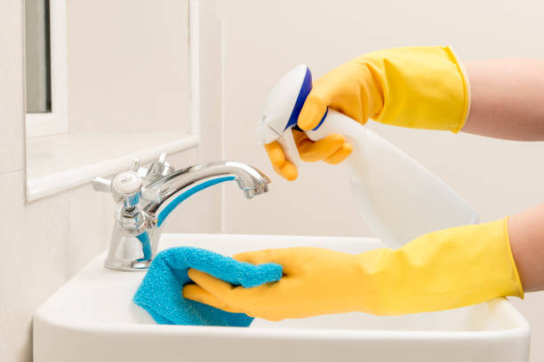 istock Hands in Gloves Spraying Liquid Soap on Rag on Bathroom Sink 869547824