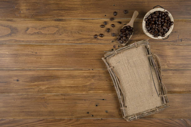 istock Coffee bean grain and sack fabrice board on brown wood table background , include copyspace for add text or graphic in advertise or marketing content 869548184