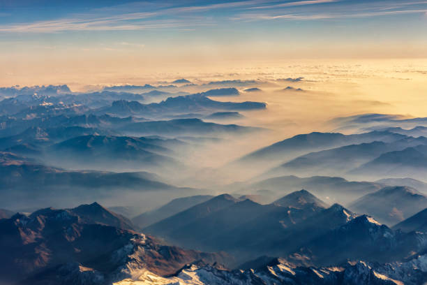 Top view from airplane, Beautiful view on the mountains from the top through the clouds.