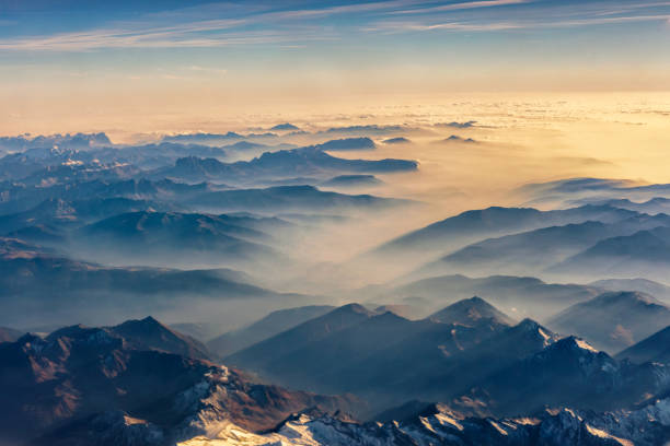Photo of Top view from airplane, Beautiful view on the mountains from the top through the clouds.