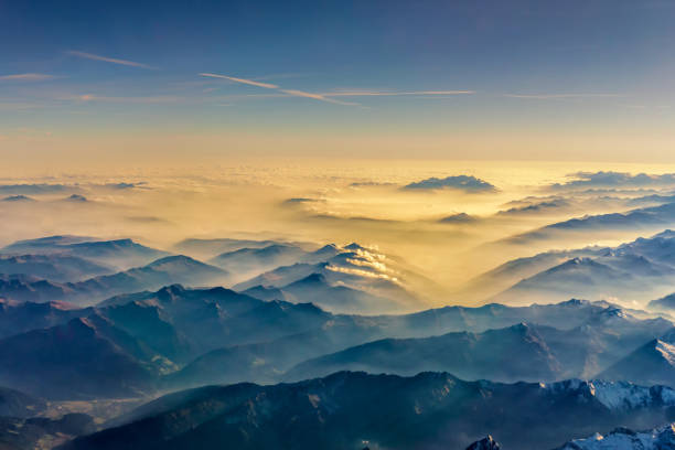 istock Top view from airplane, Beautiful view on the mountains from the top through the clouds. 869551314