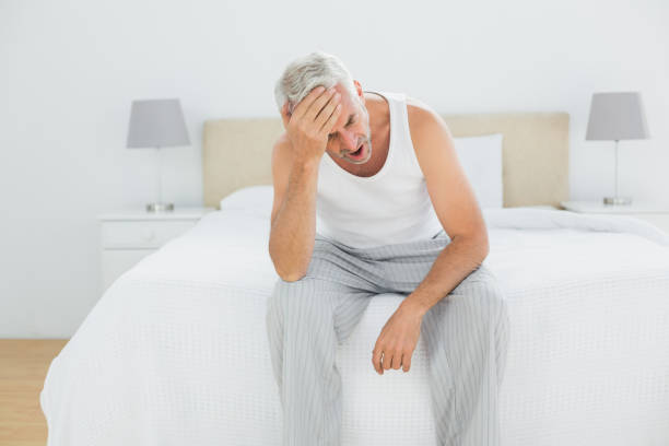 istock Thoughtful mature man yawning in bed 869557968