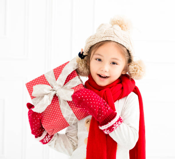 istock happy little girl showing christmas gift 869564314