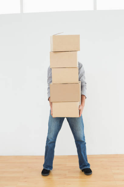 istock Obscured man carrying boxes in house 869571012