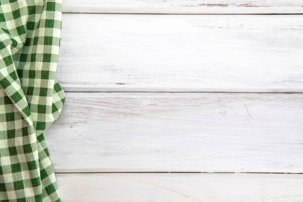 istock The Crumpled green checkered tablecloth or napkin on empty white wooden table with copy space for food cooking  menu background concept , top view or overhead shot 869573652