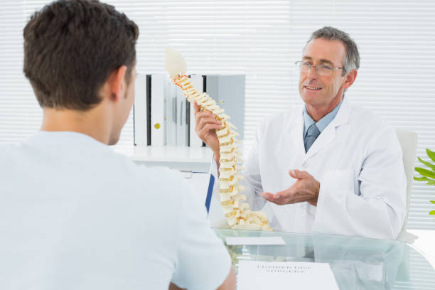 istock Doctor explaining spine to a patient in office 869576970