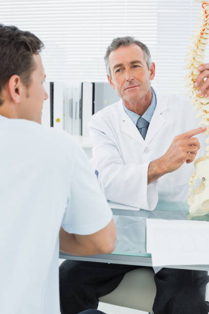 istock Doctor explaining spine to a patient in office 869576978