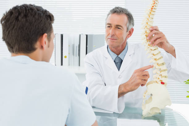 istock Doctor explaining spine to a patient in office 869576992
