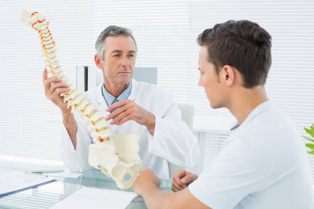 istock Doctor explaining spine to a patient in office 869577000