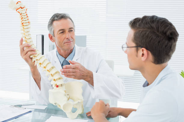 istock Doctor explaining spine to a patient in office 869577012
