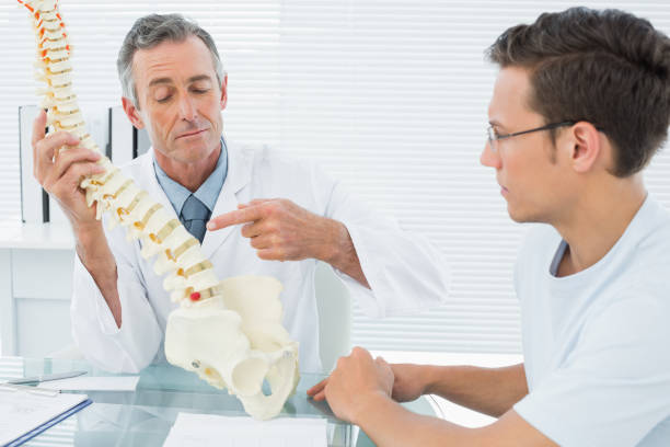 istock Doctor explaining spine to patient in office 869577026