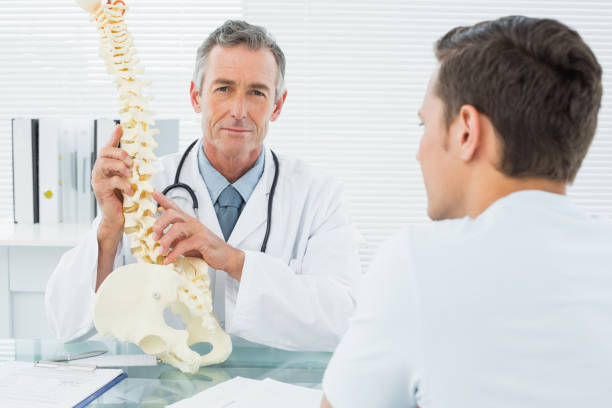 istock Doctor explaining spine to patient in office 869577040