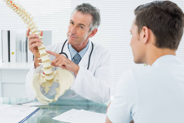 istock Doctor explaining spine to patient in office 869577044