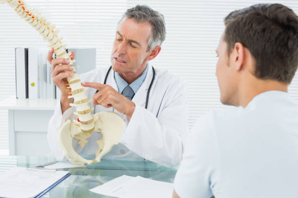 istock Doctor explaining spine to a patient in office 869577052