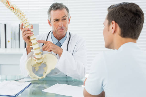 istock Doctor explaining spine to a patient in office 869577062